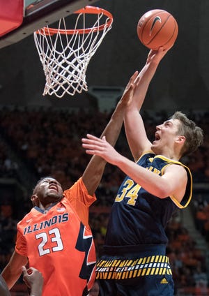 Michigan's forward Mark Donnal (34) shoots over Illinois' guard Aaron Jordan (23) during the second half of an NCAA college basketball game, Wednesday, Dec. 30, 2015, in Champaign, Ill. (AP Photo/Robin Scholz)