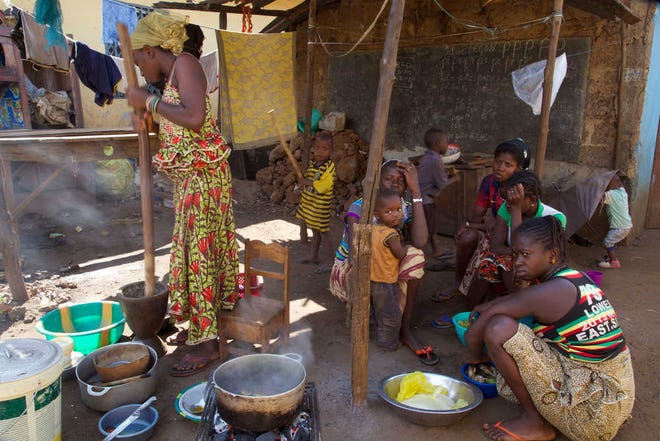 People prepare food at a home stead in the city of Conakry, Guinea, Tuesday, Dec. 29, 2015. Guinea has been declared free from transmission of Ebola, the World Health Organization said Tuesday, marking a milestone for the West African country where the original Ebola chain of transmission began two years ago leading to the largest epidemic in history. (AP Photo/ Youssouf Bah)
