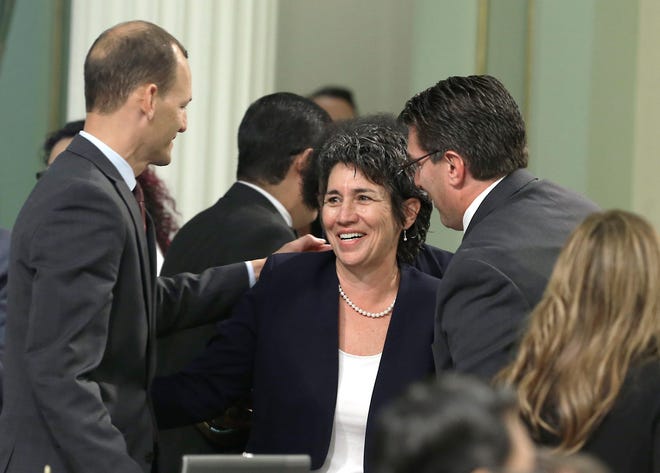 Assemblywoman Susan Eggman, D-Stockton, is congratulated Sept. 9 by Assembly members Kevin McCarty, D-Sacramento, left and Jay Obernolte, R-Big Bear Lake, after her right-to die measure was approved by the state Assembly in Sacramento. RICH PEDRONCELLI/AP