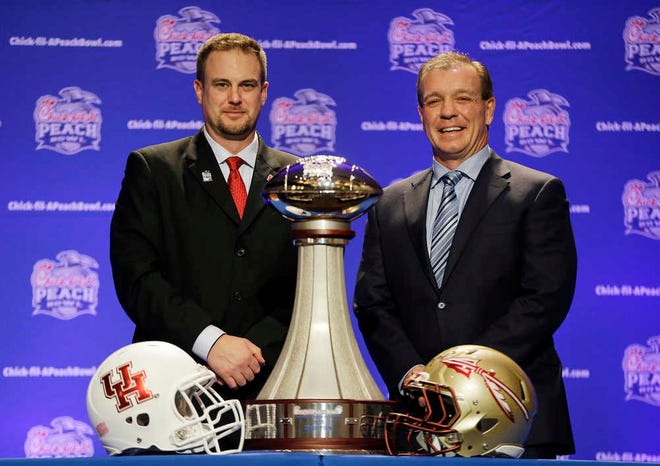 Houston head coach Tom Herman, left, and Florida State head coach Jimbo Fisher pose with the trophy during a press conference for the Peach Bowl NCAA college football game Wednesday, Dec. 30, 2015, in Atlanta. Houston plays Florida State on Thursday. (AP Photo/David Goldman)