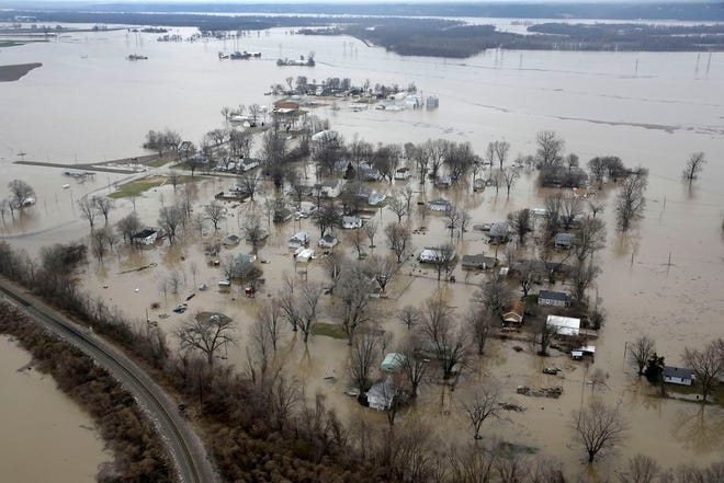 In this aerial photo, homes are surrounded by floodwater, Wednesday, Dec. 30, 2015, in West Alton, Mo. A rare winter flood threatened nearly two dozen federal levees in Missouri and Illinois on Wednesday as rivers rose, prompting evacuations in several places. (AP Photo/Jeff Roberson)
