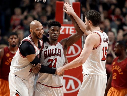 Chicago Bulls' Jimmy Butler, center, celebrates with Taj Gibson, left, and Pau Gasol after the Bulls defeated the Indiana Pacers 102-100 in overtime in an NBA basketball game Wednesday, Dec. 30, 2015, in Chicago.