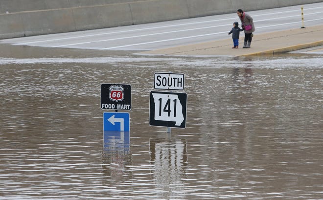 People look at floodwater from the Meramec River at the intersection of I-44 and Highway 141 in southwest St. Louis County, Wednesday, Dec. 30, 2015. A rare winter flood threatened nearly two dozen federal levees in Missouri and Illinois on Wednesday as rivers rose, prompting evacuations in several places. (J.B. Forbes/St. Louis Post-Dispatch via AP) EDWARDSVILLE INTELLIGENCER OUT; THE ALTON TELEGRAPH OUT; MANDATORY CREDIT
