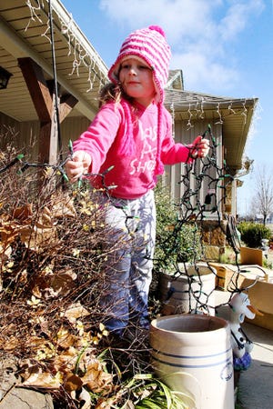 Jamie Mitchell • Times Record Hayden Watkins, 6, helps her dad, Eric Watkins, Wed Dec 30, 2015, put away the outdoor Christmas lights hanging on their Tennessee Ridge home.