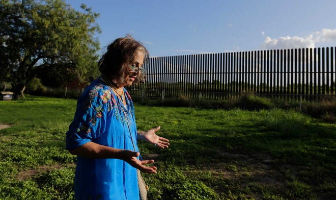 In this Sept. 17, 2015, photo, Dr. Eloisa Tamez walks in her back yard where the border fence passes through her property, in San Benito, Texas. Tamez refused to cede her three acres in San Benito for the building of the wall, land that had been in her family for generations. A federal judge ruled in the government's favor, and Tamez was compensated $56,000, with which she funded a scholarship at the University of Texas Rio Grande Valley where she works as a professor. The staggered fence or "wall," costing $6.5 million per mile, runs along about 100 miles of Texas' 1,254-mile border with Mexico. (AP Photo/Eric Gay)