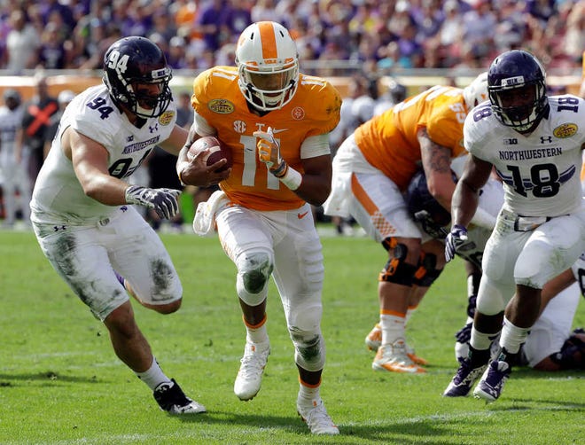 Tennessee quarterback Joshua Dobbs (11) runs away from Northwestern defensive lineman Dean Lowry (94) during the Outback Bowl NCAA college football game Friday, Jan. 1, 2016, in Tampa, Fla. (AP Photo/Chris O'Meara)