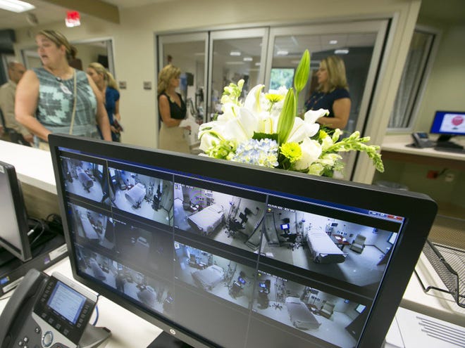 Visitors file past a nursing station during an open house tour of Ocala Regional Medical Center's new Intensive Care unit in Ocala, Florida on August 24, 2015. All rooms have cameras and are monitored from the nursing station. The $30 Million project adds 34 new intensive care beds to the facility.