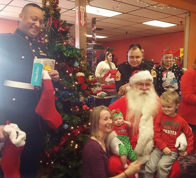 Marines, Steve Martinez and Carl Conboy, representing the Toys for Tots Program, join Santa "Ugly" George Exley as he hands out stockings stuffed with goodies to children at the annual Everyday Angels Christmas Party at Walden Lanes in Walden. Photo provided
