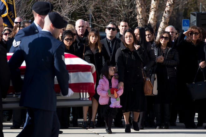 Staff Sgt. Louis Bonacasa's wife, Deborah, center, and 5-year-old daughter, Lilianna, watch as a military honor guard carries his casket into the New Beginnings Christian Center for his funeral service, Saturday in Coram. Associated Press
