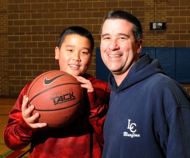 Thomas Gould and his son Daniel, 12, get ready to play basketball in Harwich. Gould, a firefighter and paramedic, worked with local physicians to develop a “return to play” protocol and created a website to educate parents, coaches and medical professionals about concussion. Ron Schloerb/Cape Cod Times