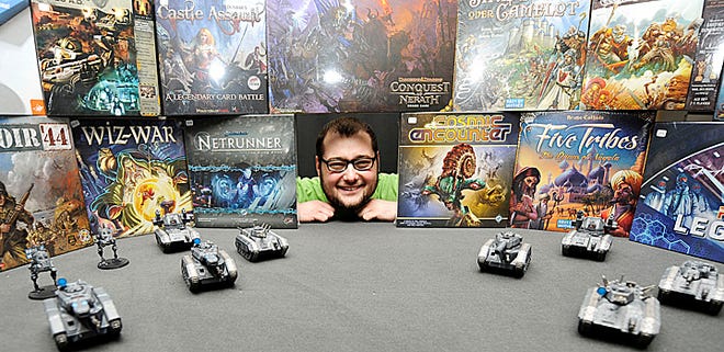 Tim Roberts, owner of Acropolis Games, 105 Sand Creek Highway in Adrian, is pictured next to popular board games. Acropolis gives fans of table-top strategy games a place to play.