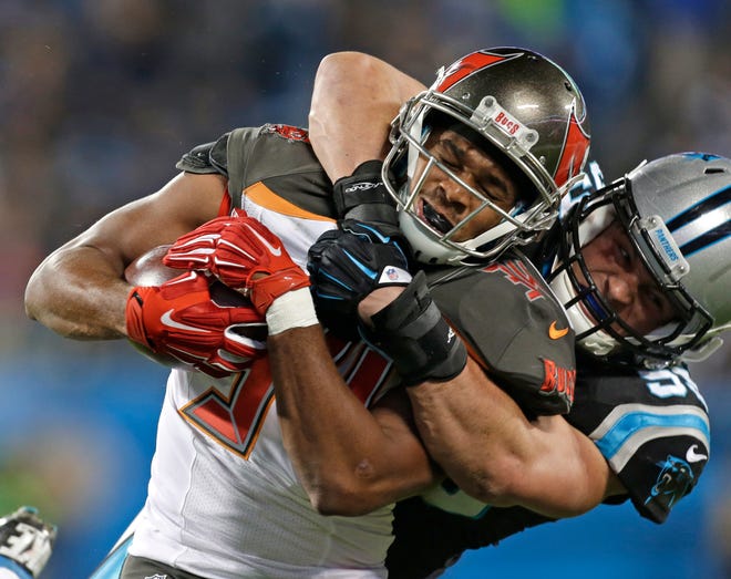 Tampa Bay Buccaneers running back Charles Sims (34) is tackled by Carolina Panthers middle linebacker Luke Kuechly (59) in the first half of an NFL football game in Charlotte, N.C., Sunday, Jan. 3, 2016.