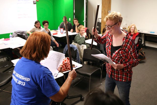 Kae Slayton, right, an intern at Literacy Works, acts out a writing exercise with a member of her group during a class of adult literary volunteers at Literacy Works in Chicago on Nov. 4, 2015. (Chicago Tribune)