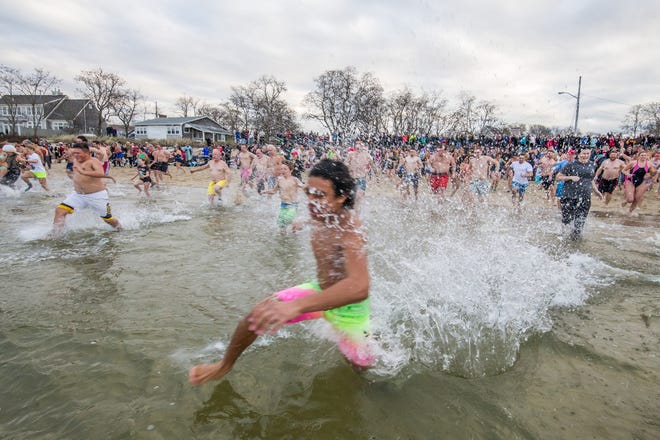 A speedy young New Year's Day Polar Plunger leads the way at Millway Beach in Barnstable.