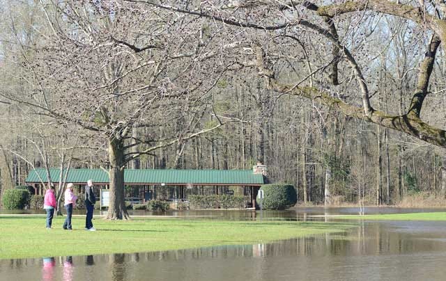 People look out at the flooded Neuseway Nature Center Park and campgrounds as the Neuse River continued to flow above flood stage Saturday.