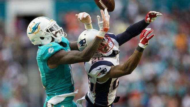 Miami Dolphins wide receiver DeVante Parker (11), juggles the ball over the New England Patriots cornerback Logan Ryan (26), and came down with the reception late in the fourth quarter of their NFL game Sunday January 03, 2016 in Miami Gardens. Final score Fins 20-10 over Pats.(Bill Ingram / The Palm Beach Post)