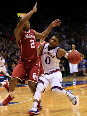 Kansas guard Frank Mason III (0) is defended by Oklahoma guard Dinjiyl Walker (2) during the first half of an NCAA college basketball game in Lawrence, Kan., Monday, Jan. 4, 2016. (AP Photo/Orlin Wagner)