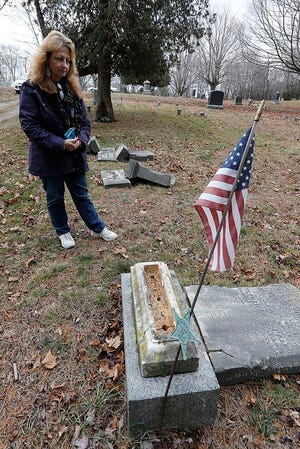 Lauren Delaney caretaker of the Pleasant Hill Cemetery in West Bridgewater looks over the toppled headstones on Friday, Jan. 1, 2016.