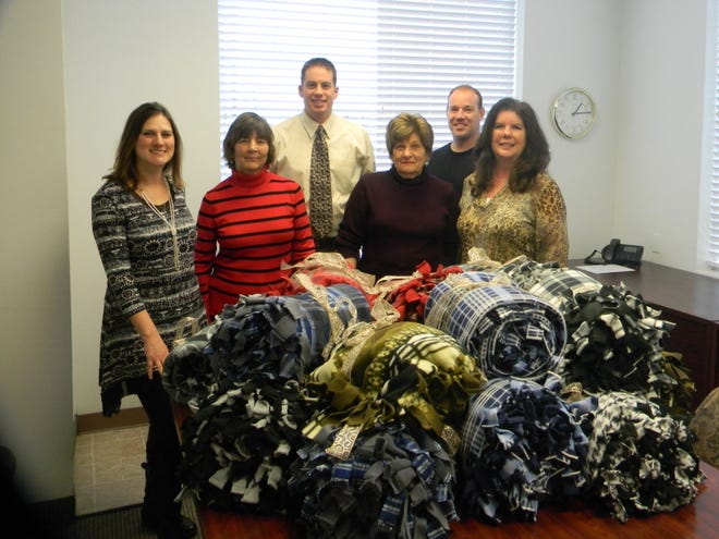 Prudential Fox & Roach Hampton Home office members display blankets to be donated to homeless Bucks  County veterans.