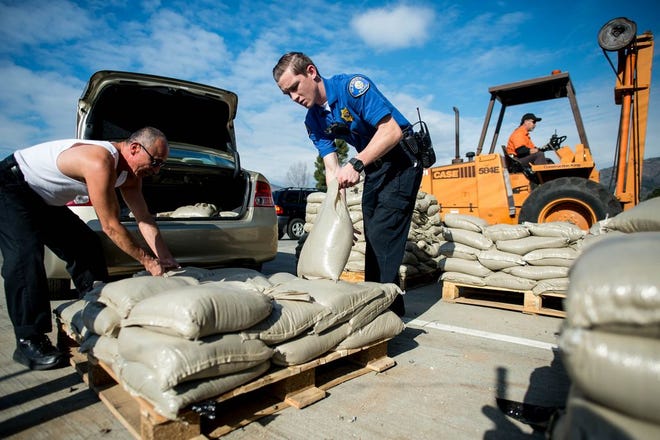 Glendora Police cadet Matt Wending, center, helps resident Frank Salazar with loading sandbags to his to car at Glendora City Yard, in Glendora, Calif., on Monday, Jan. 4, 2016, as Southern California prepare for the El Nino. The brewing El Niño system — a warming in the Pacific Ocean that alters weather worldwide — is expected to impact California and the rest of the nation in the coming weeks and months. (Watchara Phomicinda/San Gabriel Valley Tribune via AP) MAGS OUT; NO SALES; MANDATORY CREDIT