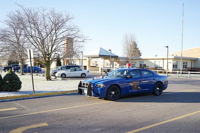 A Michigan State Police trooper is seen in his patrol car Tuesday morning outside the Madison schools. Madison Township police were assisted in investigating an online threat of violence against the Madison schools by the state police, FBI, Lenawee County Sheriff's Department and Adrian police.