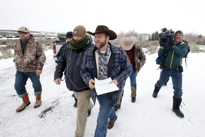 Ammon Bundy, center, one of the sons of Nevada rancher Cliven Bundy, arrives for a news conference at Malheur National Wildlife Refuge Tuesday, Jan. 5, 2016, near Burns, Ore. Law enforcement had yet to take any action Tuesday against a group numbering close to two dozen, led by Bundy and his brother, who are upset over federal land policy. (AP Photo/Rick Bowmer)