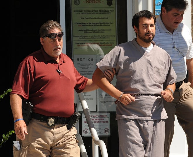 Adrian Loya, center, was escorted out of Barnstable Superior Court after a hearing last year. On Tuesday, his attorney asked for more time before announcing his planned defense. Merrily Cassidy/Cape Cod Times file