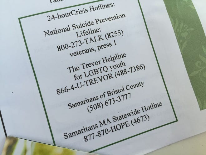 A card shows various hotlines available to help people at risk for suicidal depression.