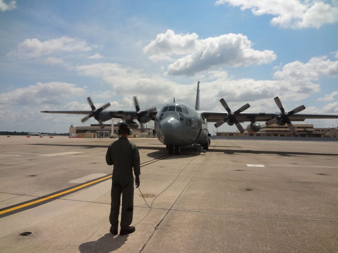 AWF2 Gage Soinski acts as a safety observer during engine start up of a C-130 Hercules aircraft.