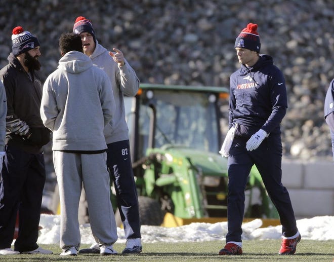 Tom Brady, right, walks onto the field for practice on Wednesday in Foxboro.