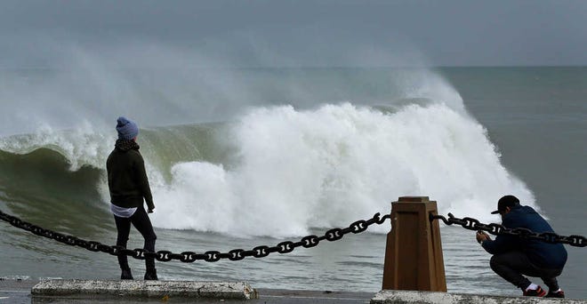 A couple take photos of waves churned by a winter storm at Fort Point on Wednesday, Jan. 6, 2016, in San Francisco Bay. El Nino storms lined up in the Pacific, promising to drench parts of the West for more than two weeks and increasing fears of mudslides and flash floods in regions stripped bare by wildfires. At least two more storms are expected to follow bringing as much as 3 inches of rain. (AP Photo/Ben Margot)