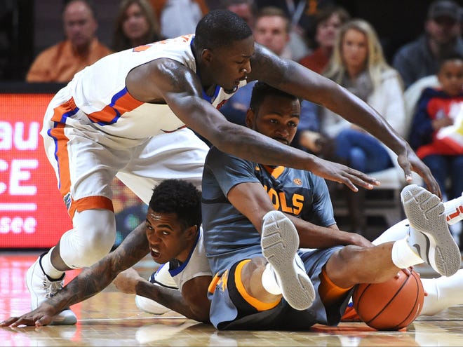 Florida forward Dorian Finney-Smith (10), top, and guard Kasey Hill (0), bottom left, swarm Tennessee guard Kevin Punter for a loose ball during the second half of an NCAA college basketball game Wednesday, Jan. 6, 2016, in Knoxville, Tenn. Tennessee won 83-69.