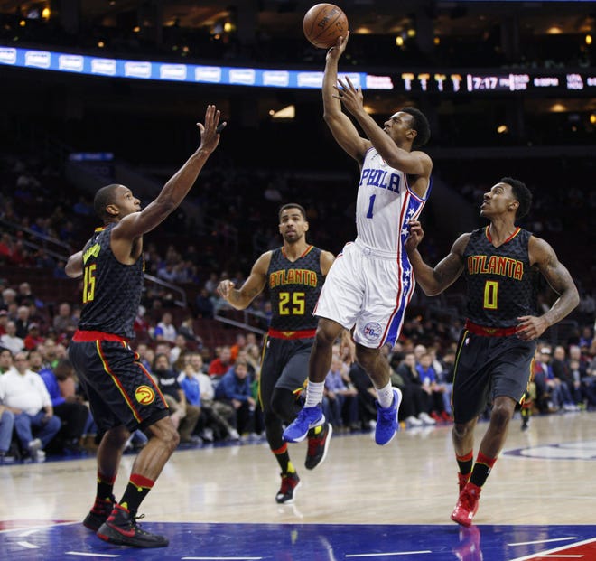 The 76ers' Ish Smith releases a shot as the Hawks' (from left) Al Horford, Thabo Sefolosha and Jeff Teague defend Thursday night, Jan. 7, 2016, at the Wells Fargo Center.