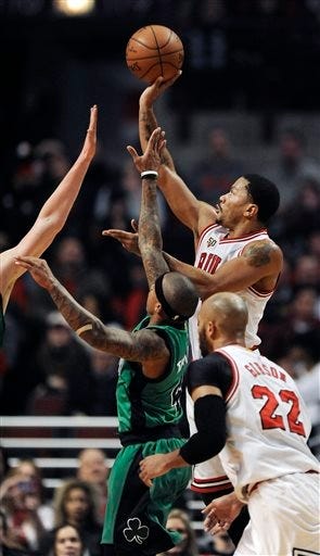 Chicago Bulls' Derrick Rose (1), goes up for a shot against Boston Celtics' Isaiah Thomas (4), and Kelly Olynyk (41), during the first half of an NBA basketball game Thursday, Jan. 7, 2016, in Chicago.