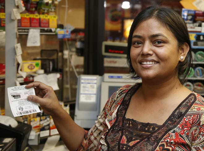 Momtaz Parvin prepares to deliver a Powerball ticket to a customer at her store in Oklahoma City, Friday, Jan. 8, 2016, as the multi-state jackpot reaches $800 million. With ticket sales doubling previous records, the odds are growing that someone will win Saturday’s record jackpot, but if no one wins the top prize, next week’s drawing is expected to soar past $1 billion. (AP Photo/Sue Ogrocki)