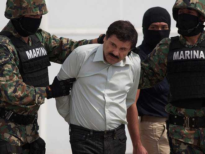 In this Feb. 22, 2014 file photo, Joaquin "El Chapo" Guzman is escorted by Mexican navy marines. Mexican President Enrique Pena Nieto posted on his Twitter account Friday that Guzman has been recaptured.