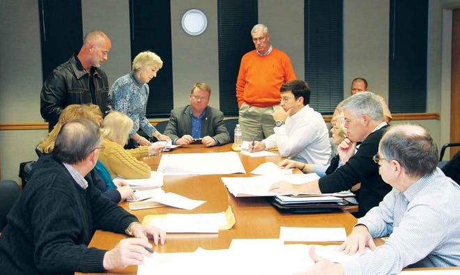 The Oak Ridge Municipal Planning Commission, city staff and RealtyLink Project Manager Matt Usry, in the leather jacket at left, look over plans Thursday night.