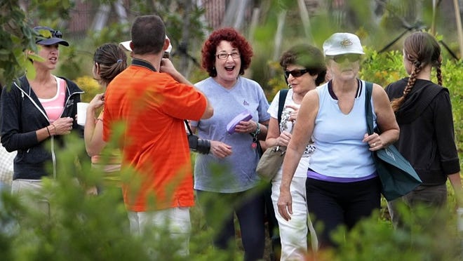 Wendy Latman, (C), smiling, and friend Joan Ross, (3R), join twenty other area residents in a tour of the Old Dixie Eco Walk a quarter mile of land once a median now reforest into a butterfly garden Tuesday, Apr 22, 2014 in Boynton Beach. The walk was part of the City of Boynton Beach Earth Week events. The project is a partnership between the Arts in Public Spaces, and the Seabourn Cove community. (Bill Ingram / Palm Beach Post)