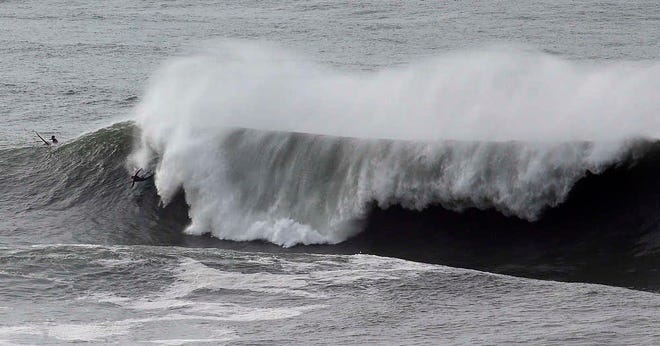 A surfer wipes out under a large wave Friday, Jan. 8, 2016, at Mavericks in Half Moon Bay, Calif. (AP Photo/Ben Margot)