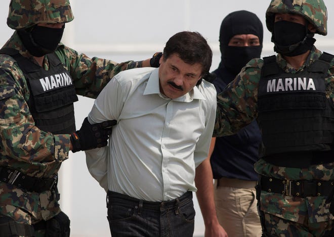 FILE - In this Feb. 22, 2014 file photo, Joaquin "El Chapo" Guzman is escorted to a helicopter in handcuffs by Mexican navy marines at a navy hanger in Mexico City, Mexico. Mexican President Enrique Pena Nieto posted on his Twitter account, Friday, Jan. 8, 2016, that drug lord Joaquin 'Chapo' Guzman has been recaptured. (AP Photo/Eduardo Verdugo, File)