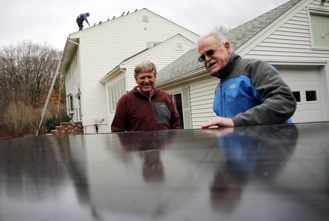 Ipswich home owner Ken Teague, left, talks with Tim Sanborn of Cazeault Solar and Home before solar panels are installed on his home on Herrick Dr. in Ipswich, Thursday, Dec. 3, 2015. Wicked Local Staff Photo / Kirk R. Williamson