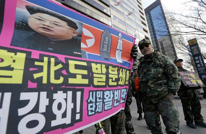 A banner shows a picture of North Korean leader Kim Jong Un as South Korean war veterans stage a rally against North Korea in Seoul, South Korea, Saturday, Jan. 9, 2016. North Korea trumpets a hydrogen bomb test. South Korea responds by cranking up blasts of harsh propaganda from giant green speakers aimed across the world's most dangerous border. The letters at a banner read "Smash the North Korean provocation which threatens peace of global village!" (AP Photo/Ahn Young-joon)