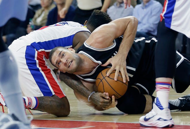 Nets center Brook Lopez fights for possession with Pistons guard Brandon Jennings during the first half Saturday night in Auburn Hills, Mich. The Associated Press