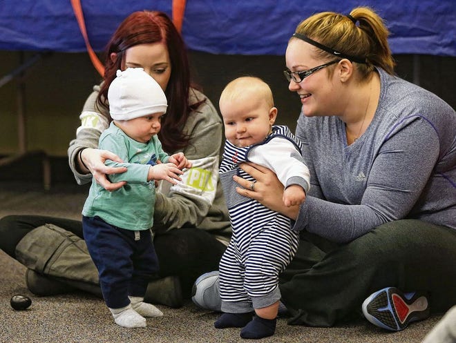 Summer Borden holds 4-month-old Finley as Whitney Sewell holds 6-month-old Charley during a song about dancing. The Bay County Public Library offers a language enrichment program called Book Babies for children up to two years old on Tuesdays at 9:30a.m. (Patti Blake | The News Herald)