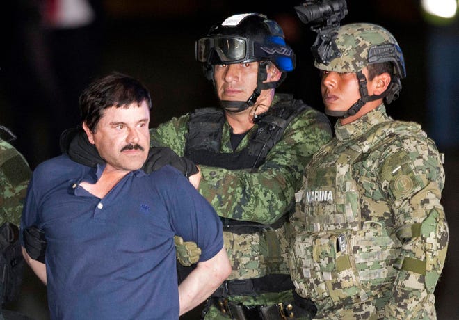 Joaquin "El Chapo" Guzman is made to face the press as he is escorted to a helicopter in handcuffs by Mexican soldiers and marines at a federal hangar in Mexico City, Mexico, Friday, Jan. 8, 2016. Mexican President Enrique Pena Nieto announced that Guzman had been recaptured six months after escaping from a maximum security prison. (AP Photo/Eduardo Verdugo)