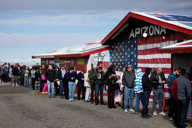 Customers wait in line at The Last Stop to buy Powerball lottery tickets Sunday, Jan. 10, 2016, in White Hills, Ariz. No ticket matched all six Powerball numbers following the drawing for a record jackpot of nearly $950 million, lottery officials said early Sunday, Jan. 10, boosting the expected payout for the next drawing to a whopping $1.3 billion.