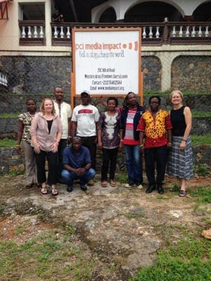 Linda West, second from left, poses outside the PCI Media Impact building where she worked while volunteering in Sierra Leone. Submitted.