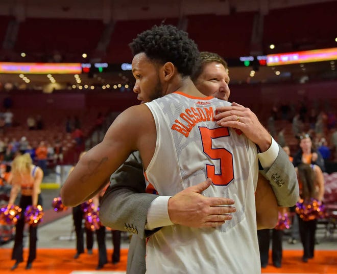 Clemson head coach Brad Brownell, right, hugs Jaron Blossomgame after an NCAA college basketball game against Louisville, Sunday, Jan. 10, 2016, in Greenville, S.C. (AP Photo/Richard Shiro)