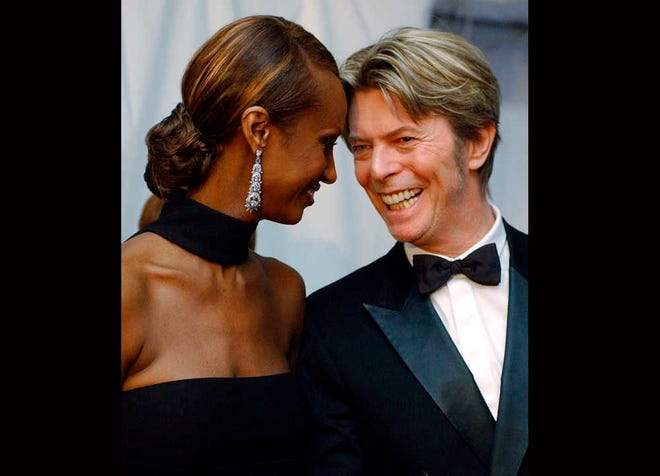 CORRECTS DATE OF DEATH TO SUNDAY, JAN. 10, 2016 - FILE - In this June 3, 2002, file photo, Iman, left, and her husband, singer David Bowie arrive at the Council of Fashion Designers of America Fashion Awards in New York. Bowie, the innovative and iconic singer whose illustrious career lasted five decades, died Sunday, Jan. 10, 2016, after battling cancer for 18 months. He was 69. (AP Photo/Suzanne Plunkett, File)