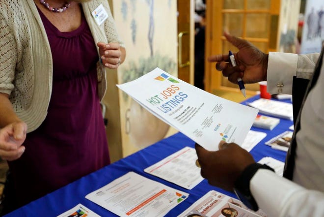 In this Tuesday, Oct. 6, 2015, photo, military veteran Mark Cannon, of Miami, right, talks with Cynthia Carcillo, left, a veterans outreach representative for Career Source Broward, about employment opportunities at a job fair for veterans, in Pembroke Pines, Fla. Fewer Americans applied for unemployment claims last week, another sign of strength in the job market. Weekly applications for unemployment benefits fell 11,000 last week to a seasonally adjusted 271,000, the Labor Department said Thursday, Dec. 17, 2015(AP Photo/Lynne Sladky)